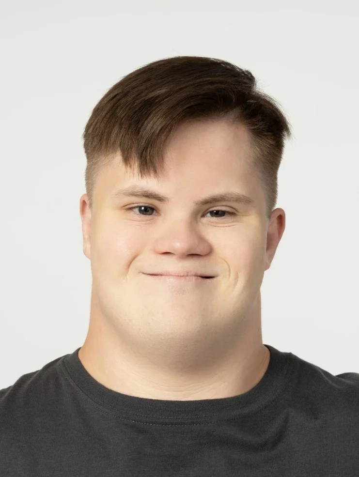 Man with down syndrome smiling at camera